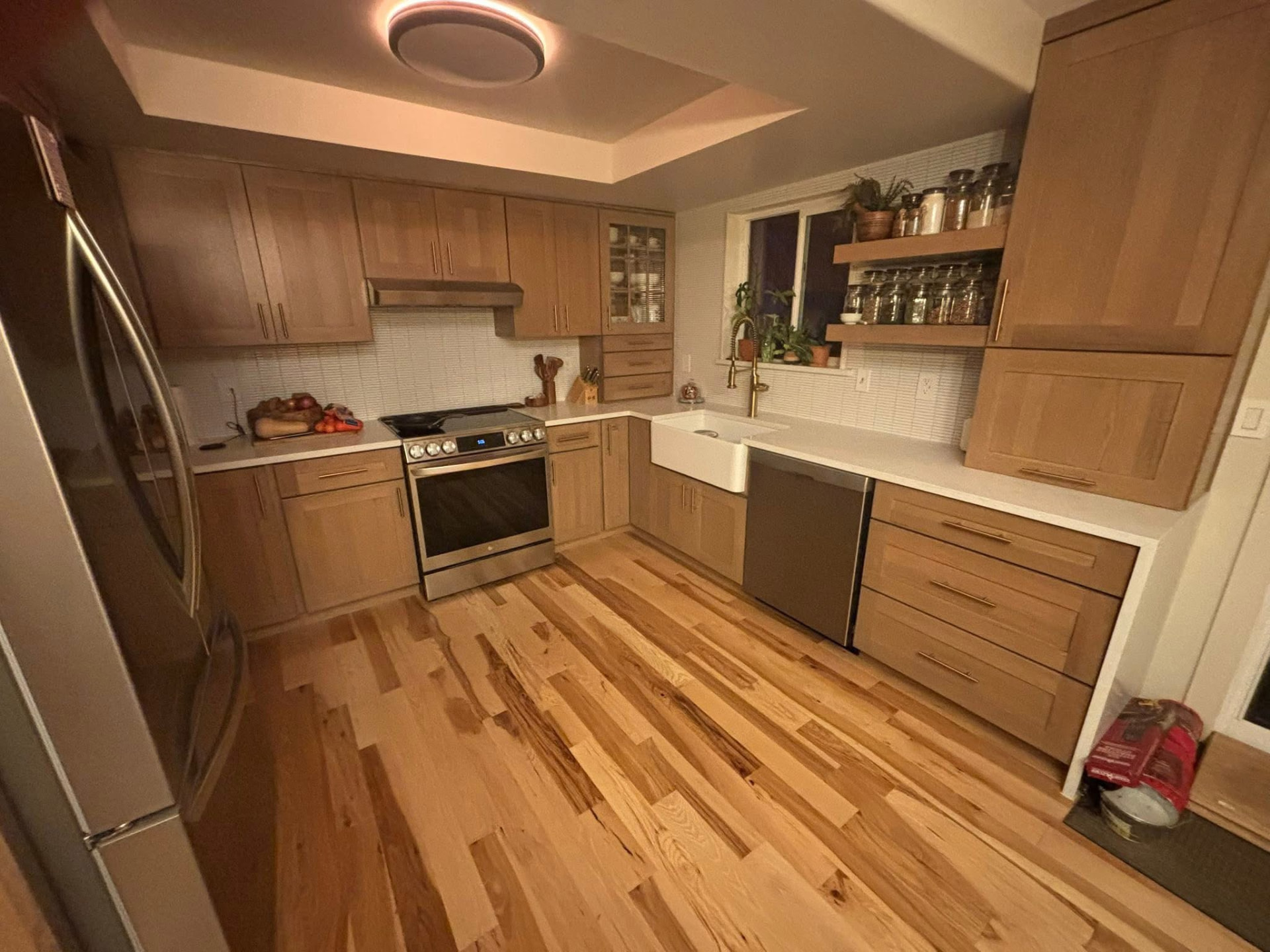 Remodeled kitchen with quarter-sawn oak cabinetry, white quartz counters, farmhouse sink and hickory hardwood floors